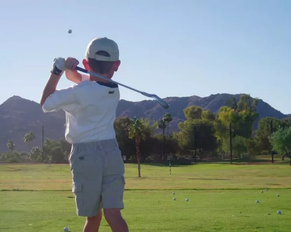 niño jugando al golf